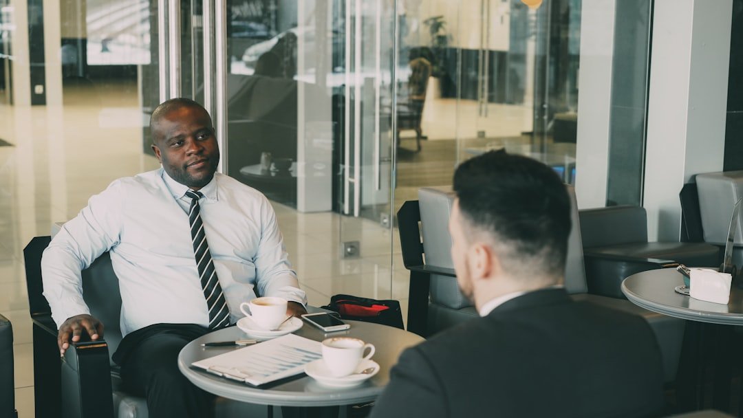 Two men talking across from each other at a desk